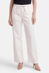 Pantalon blanc large de ONLY avec taille élastiquée et cordon, porté avec des escarpins nude.