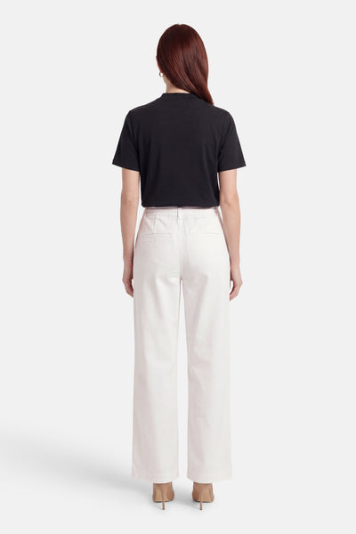 Pantalon blanc de ONLY®, vue de dos, coupe large avec poches arrière, porté avec un t-shirt noir et des talons beiges.