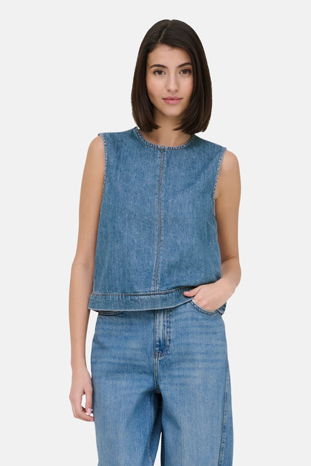 Blouse sans manches en jean bleu clair de JDY avec col rond et couture centrale, portée avec un jean.