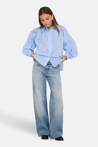 Blauwe blouse met lange mouwen van ONLY, gedragen met een wijde high-waist jeans.