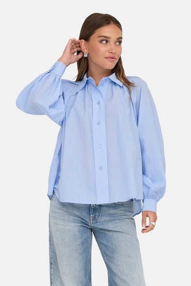 Blauw overhemd met lange mouwen van ONLY, gedragen met een spijkerbroek en vierkante oorbellen