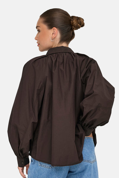Chemisier brun à manches longues par ONLY®, porté avec un jean taille haute bleu.