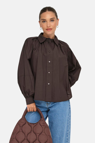 Chemise à manches longues marron, de ONLY®, avec manches bouffantes et jeans bleu clair.
