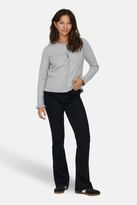 Grijze cardigan van ONLY, gedragen met een zwarte jeans en sportschoenen.