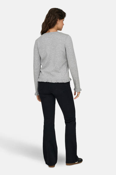 Cardigan gris par ONLY®, avec des manches longues, ourlet et poignets à volants, porté avec un jean évasé.
