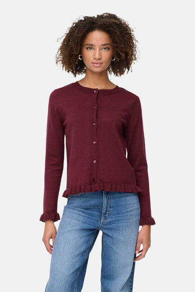 Cardigan bordeaux from ONLY®, avec des boutons, une bordure à volant et porté avec un jean bleu.
