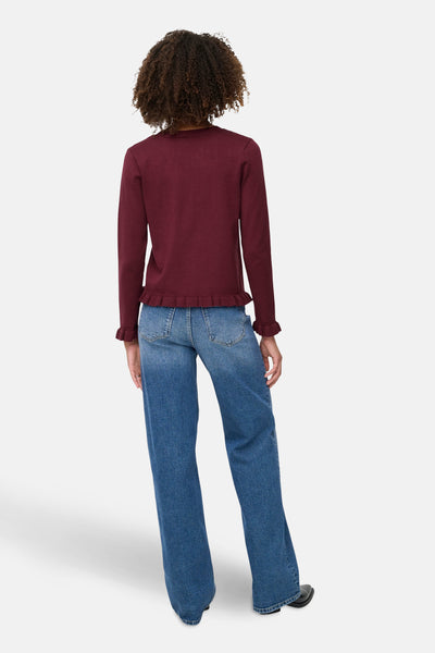 Bordeaux gebreid vest, van ONLY®, met decoratieve ruches aan de zoom en manchetten, gedragen met een high-waist jeans.