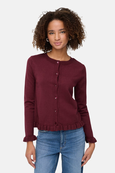 Cardigan bordeaux de ONLY®, avec des boutons et un volant décoratif sur le bas et les manches, porté sur un jean bleu.
