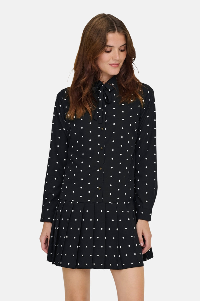 Robe noire à manches longues de ONLY, à pois blancs, avec un col à nouer et une jupe plissée.
