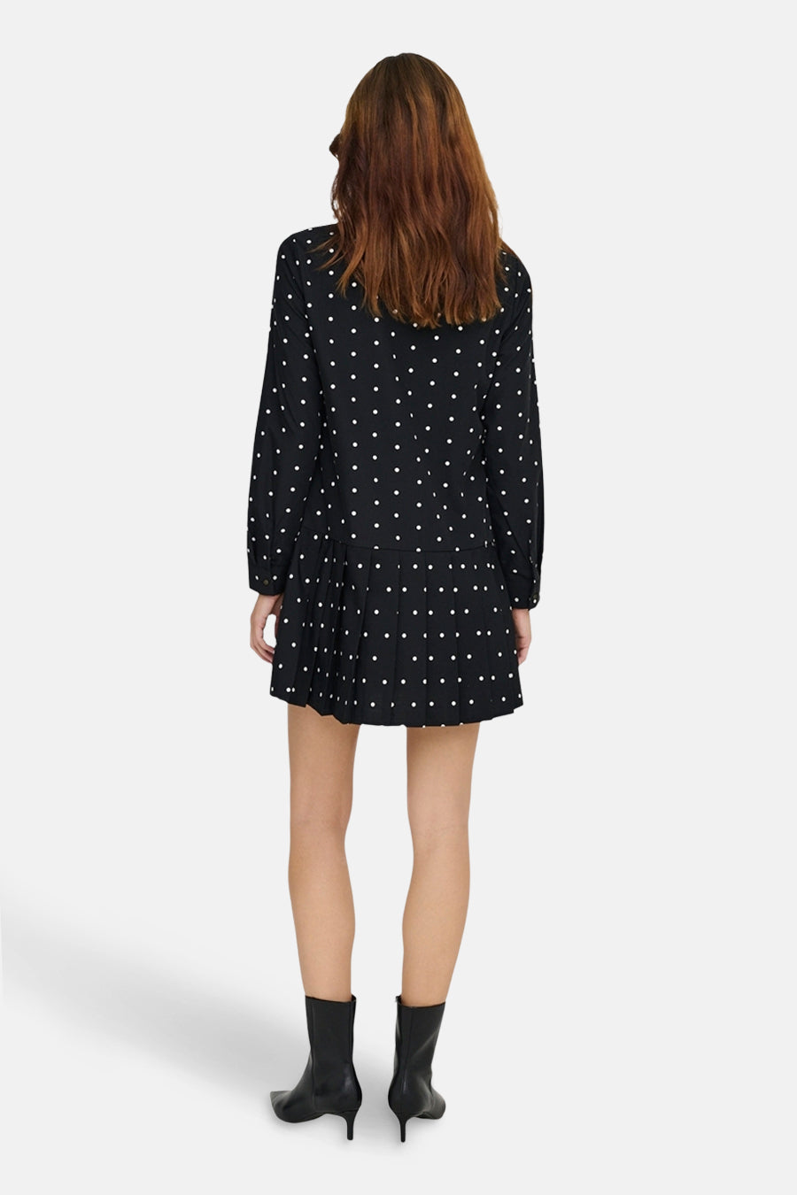 Robe noire à pois blancs de ONLY, vue de dos, portée avec des bottines noires.
