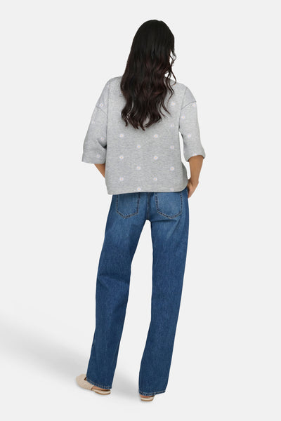 Sweat-shirt gris à col rond de ONLY®, à motif floral et manches mi-longues, porté avec un jean bleu.
