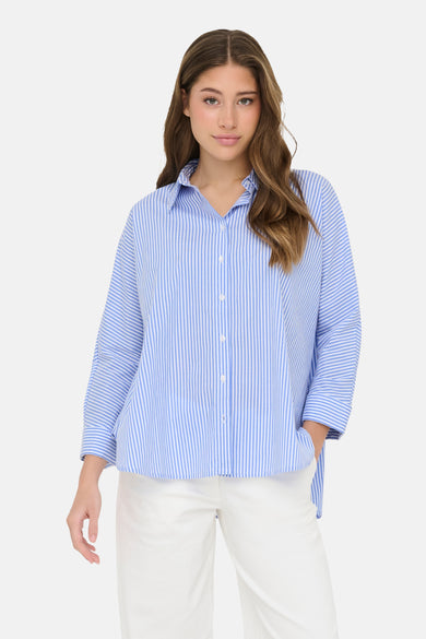Chemise à manches longues bleu rayé de ONLY®, portée avec un pantalon blanc.