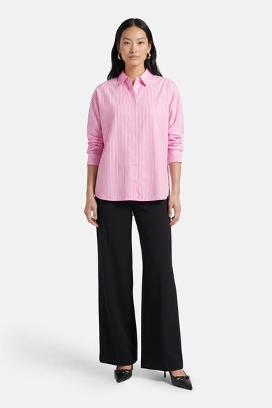 Chemise à manches longues rose rayée, de ONLY®, portée avec un pantalon noir ample et des escarpins noirs.
