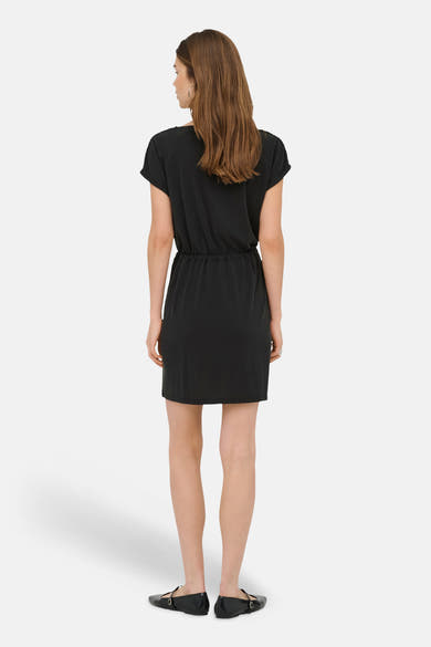 Robe noire de ONLY®, vue de dos, à manches courtes, avec taille coulissée, portée avec des chaussures plates noires.