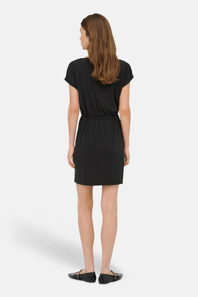 Robe noire de ONLY®, vue de dos, à manches courtes, avec taille coulissée, portée avec des chaussures plates noires.