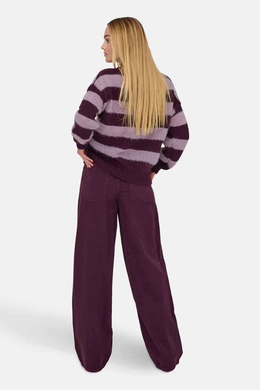 Ronde hals trui paars ONLY®, met horizontaal strepenpatroon, gedragen met een wijde bordeauxrode broek.