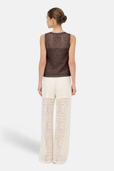 Top sans manches brun de ONLY en crochet avec motifs, porté avec un pantalon écru en crochet.