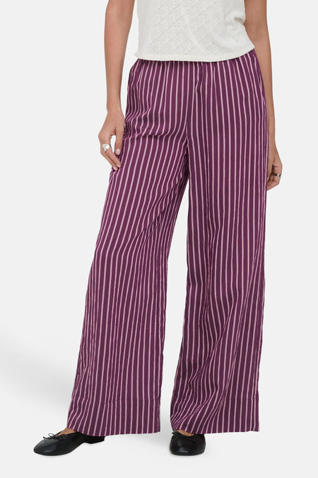 Pantalon large violet de ONLY à rayures verticales roses pâles, porté avec un haut blanc et des chaussures noires.