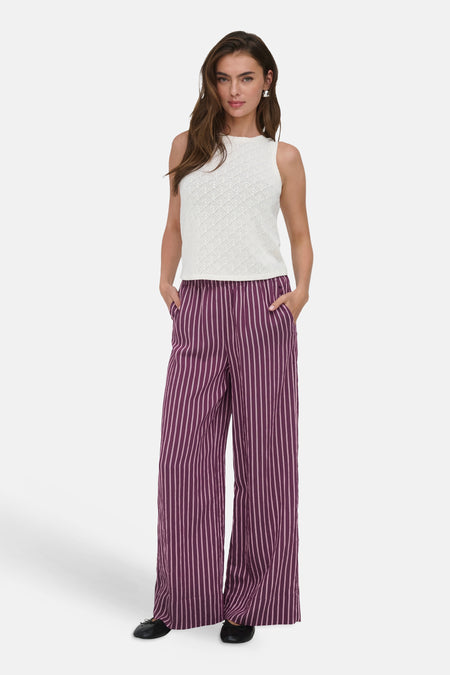 Pantalon violet de ONLY®, rayé, coupe large. Porté avec un débardeur blanc et des chaussures plates noires.