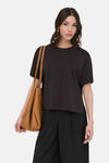 Pull col O brun de JDY, gedragen met een wijde zwarte broek en een bruine shopper tas.