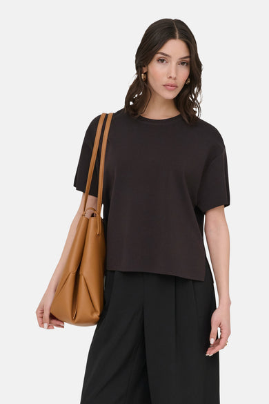 Pull col O brun de JDY, porté avec un pantalon noir et un sac à main marron.
