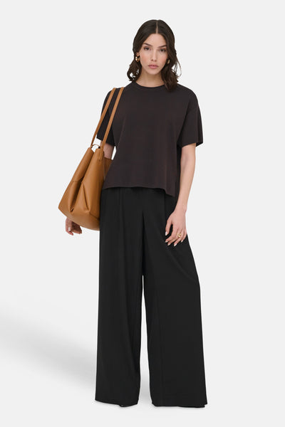 Pull col O brun de JDY, porté avec un pantalon noir ample et un sac cabas marron.