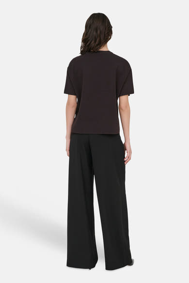 Bruine trui van JDY, van achteren gezien, gedragen met een wijde zwarte broek.
