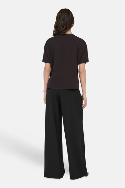 Pull brun de JDY, vu de dos, porté avec un pantalon noir ample.