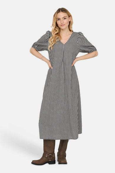 Robe longue à carreaux multicolores de JDY, avec manches courtes bouffantes et bottes marron.

