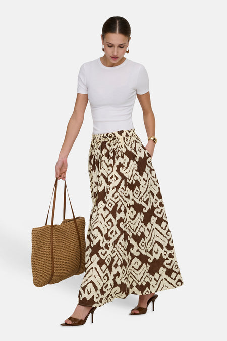 Jupe longue multicolore de JDY, motif imprimé, portée avec un t-shirt blanc et des sandales à talons.