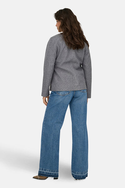 Veste courte gris chiné de ONLY, portée avec un jean large taille haute et des bottines marron.