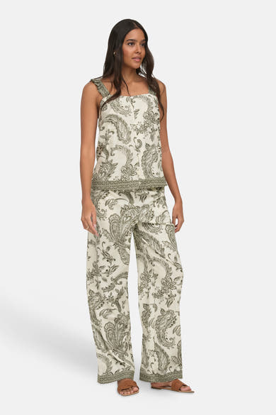 Ivy green sleeveless blouse with floral paisley print and ruffled straps, paired with matching wide-leg pants, full-length front view