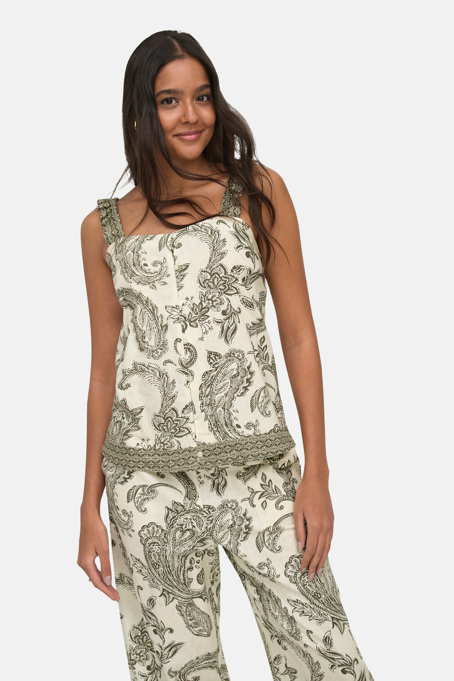 Ivy green sleeveless blouse with floral paisley print and ruffled straps, front view on model wearing matching pants