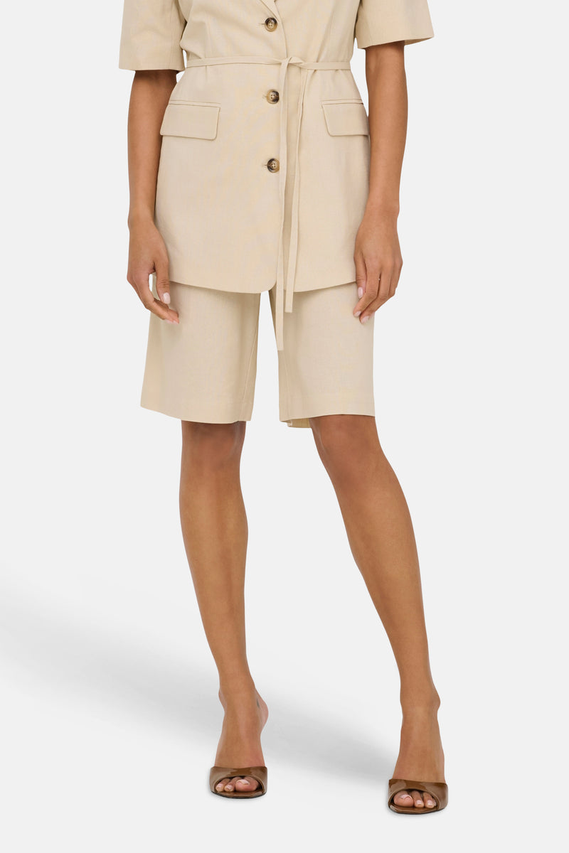 Beige Bermuda van JDY, rechte snit boven de knie, gedragen met een bijpassende blazer en bruine muiltjes.