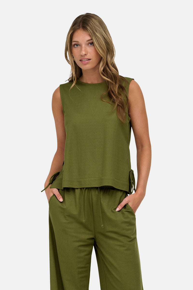 Olive green sleeveless blouse with side ties and relaxed fit, front view on model wearing matching pants