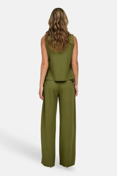 Olive green sleeveless blouse with structured back hem, worn with matching wide-leg trousers, back view.