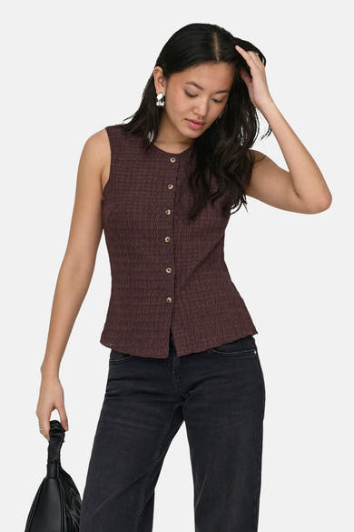 Bruin textiel gilet van ONLY, gedragen met een zwarte jeans en zwarte leren schoenen.