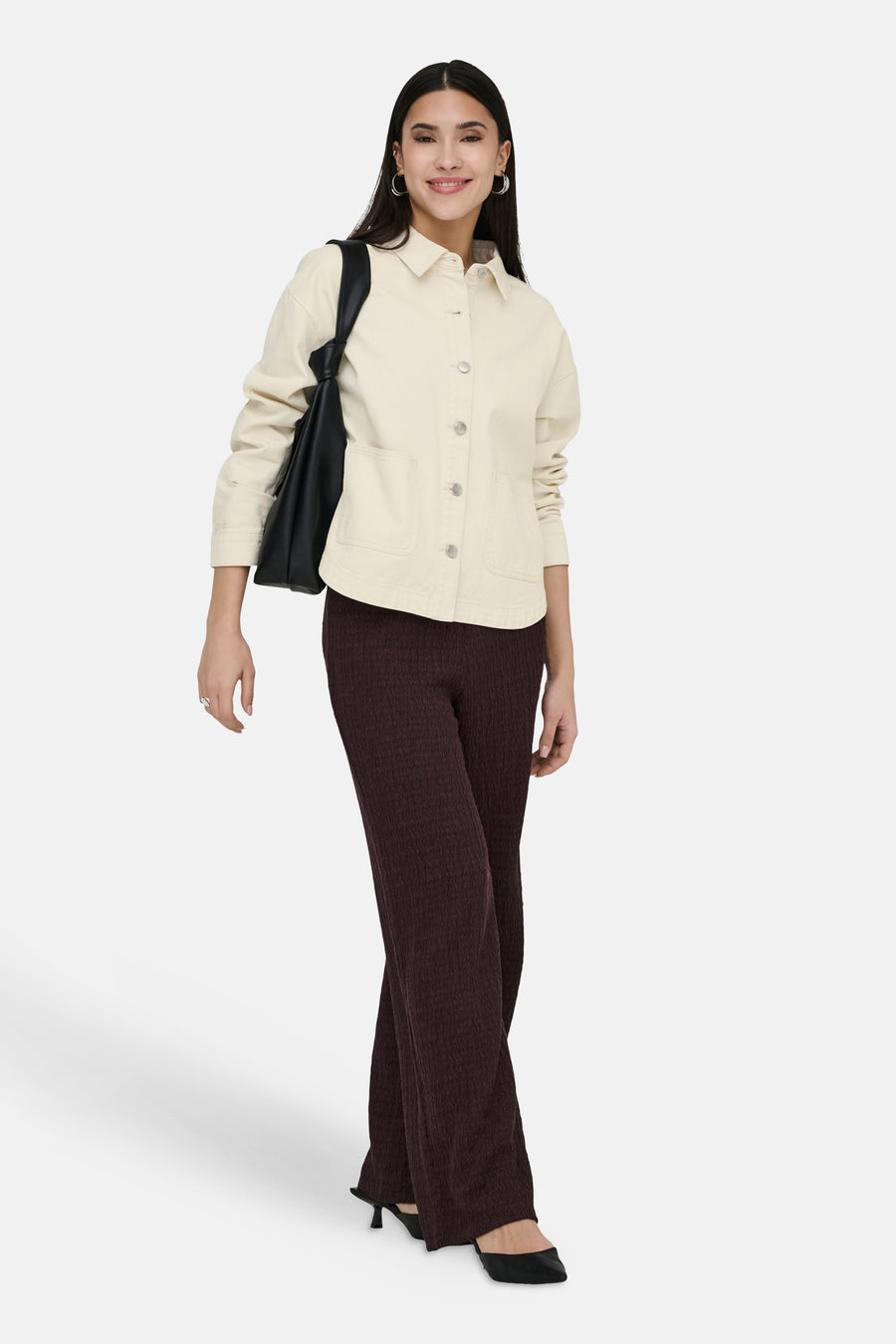 Pantalon brun texturé de ONLY, avec une coupe évasée et des chaussures noires à talons.
