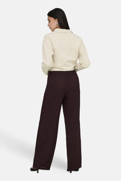 Pantalon brun à texture plissée de ONLY, porté avec une chemise beige à manches longues.