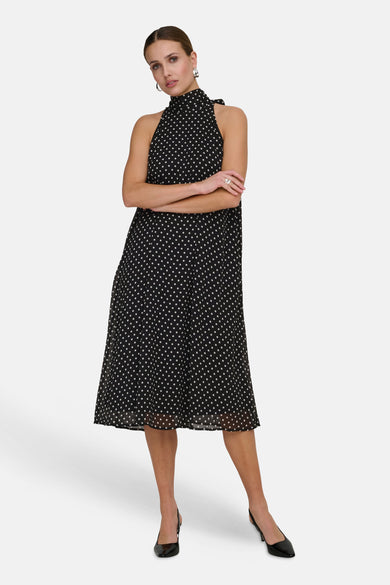 Robe noire de JDY à pois blancs, coupe mi-longue évasée et col montant noué.