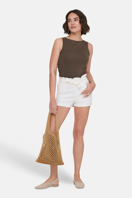 Top sans manches brun de ONLY, porté avec un short blanc taille haute et des chaussures plates.