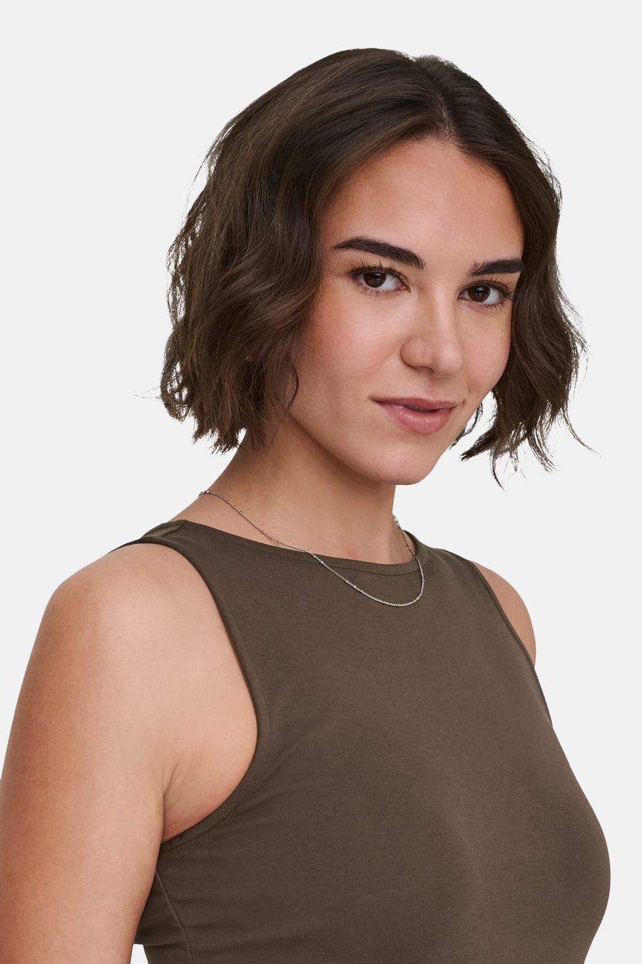 Mouwloos bruin topje van ONLY, gedragen met een fijne zilveren ketting.