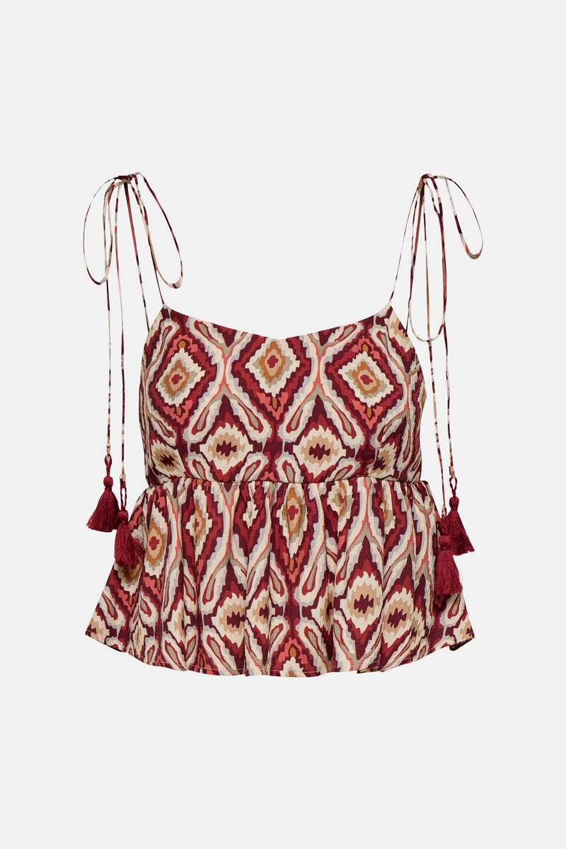 Brick red sleeveless blouse with geometric ikat print and tassel ties, front view