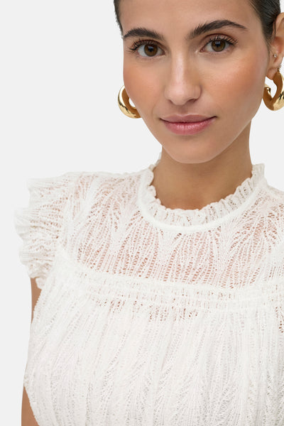 White sleeveless lace top with ruffled cap sleeves and smocked bodice, close-up front view