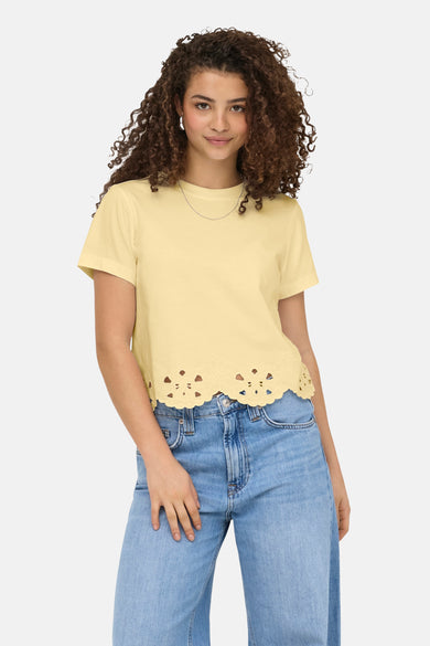 T-shirt jaune de ONLY avec ourlet festonné à découpes, porté avec un jean et un collier fin.
