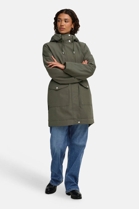 Parka kaki JDY à capuche portée par un mannequin, avec poches à rabat et jeans bleus.