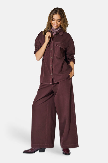 Chemise à manches longues bordeaux ONLY® portée par un mannequin, avec col classique, boutons et poches à rabat.