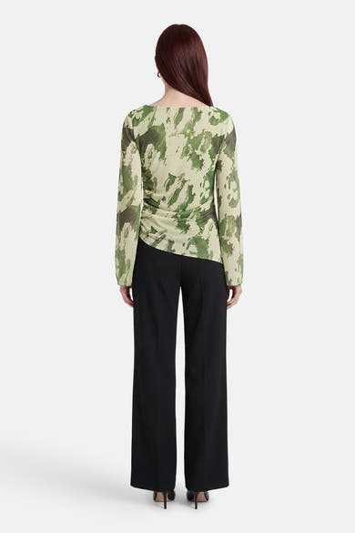 T-shirt à manches longues vert de JDY, avec motif camouflage, porté avec un pantalon noir taille haute.