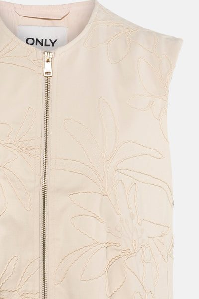 Beige mouwloos vest van ONLY, versierd met geborduurde bloemenpatronen, gouden ritssluiting.