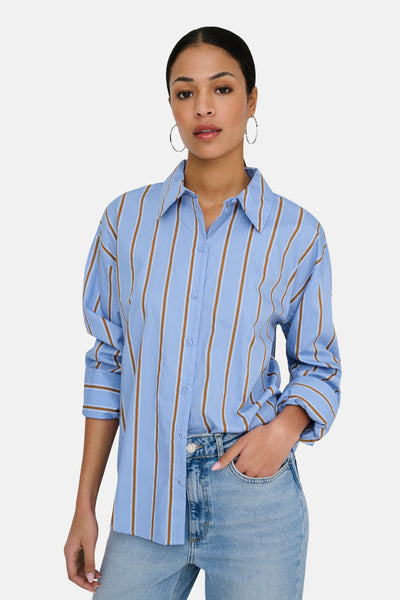 Light blue long-sleeve striped chemise with brown and white vertical stripes, button-down front, rolled sleeves, worn with light wash jeans and hoop earrings.